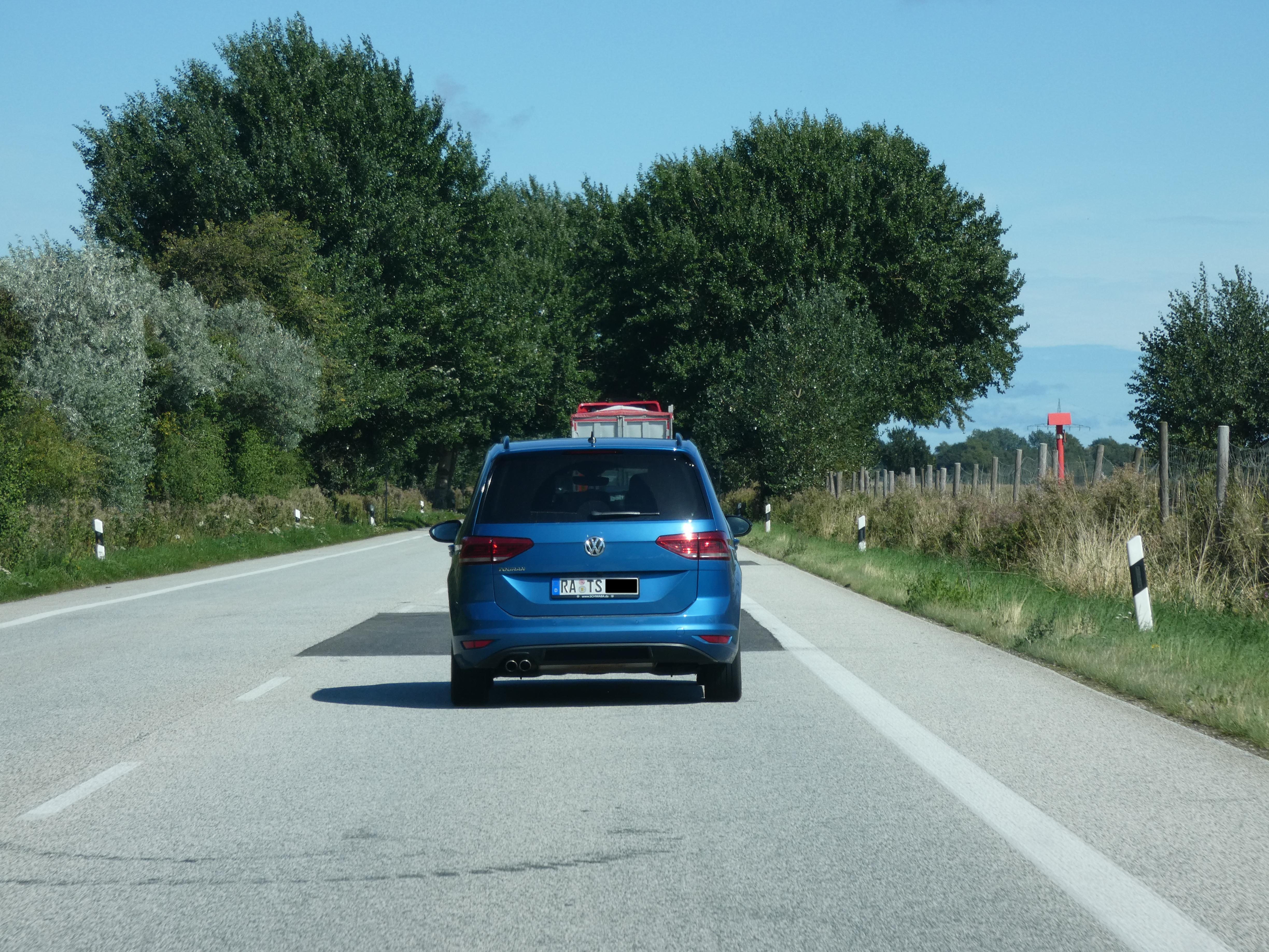 A car with a license plate spelling “RA TS” and a censored number